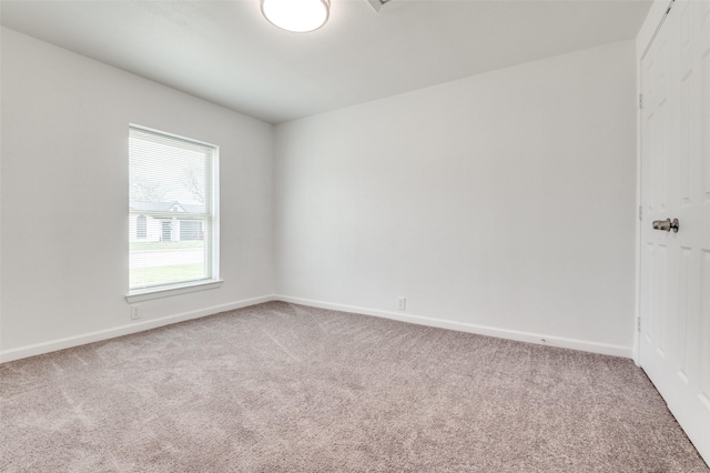 carpeted empty room with baseboards