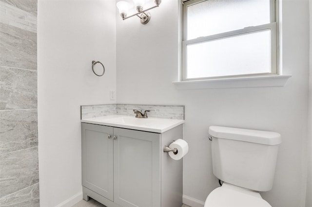 bathroom featuring baseboards, tasteful backsplash, toilet, and vanity