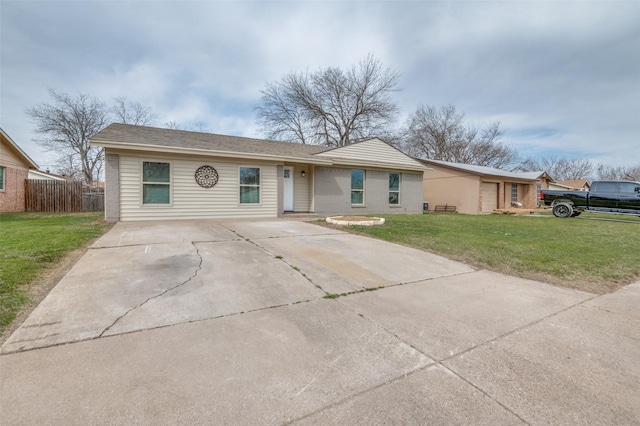 ranch-style home featuring driveway, brick siding, a front lawn, and fence