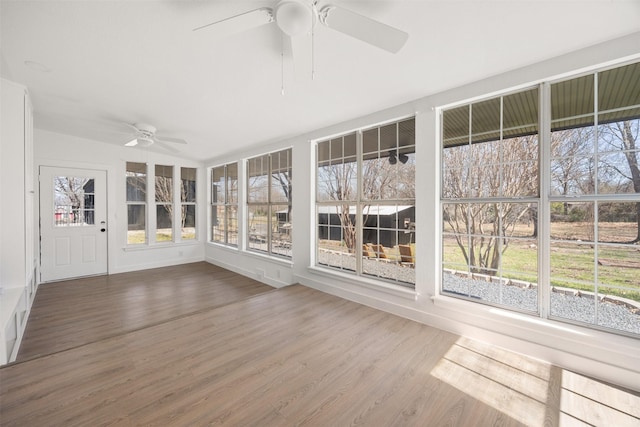 unfurnished sunroom featuring a healthy amount of sunlight and a ceiling fan