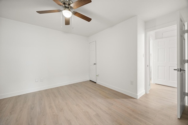 unfurnished room featuring a ceiling fan, light wood-style floors, and baseboards