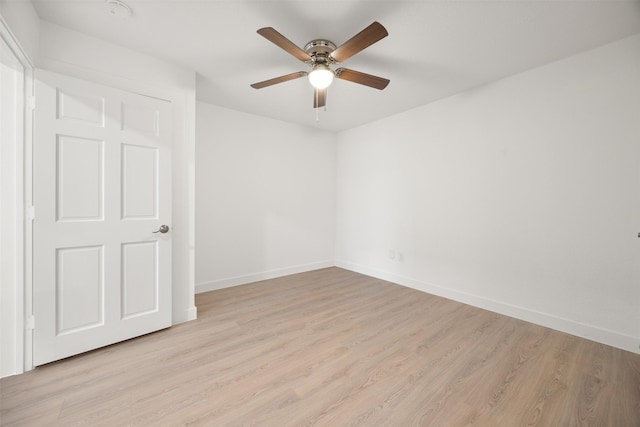 empty room featuring light wood-type flooring, baseboards, and a ceiling fan