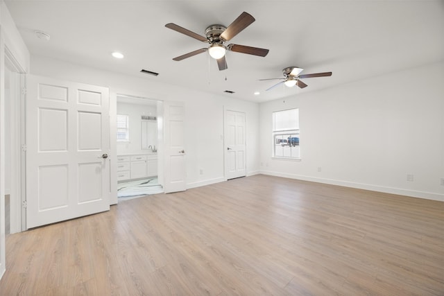 unfurnished bedroom featuring visible vents, multiple windows, baseboards, and light wood-style flooring