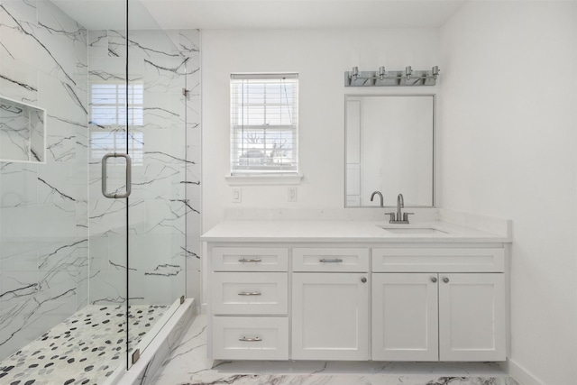 full bath featuring a marble finish shower, baseboards, marble finish floor, and vanity