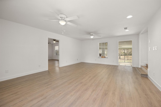 unfurnished living room with stairway, baseboards, light wood-style floors, and a ceiling fan