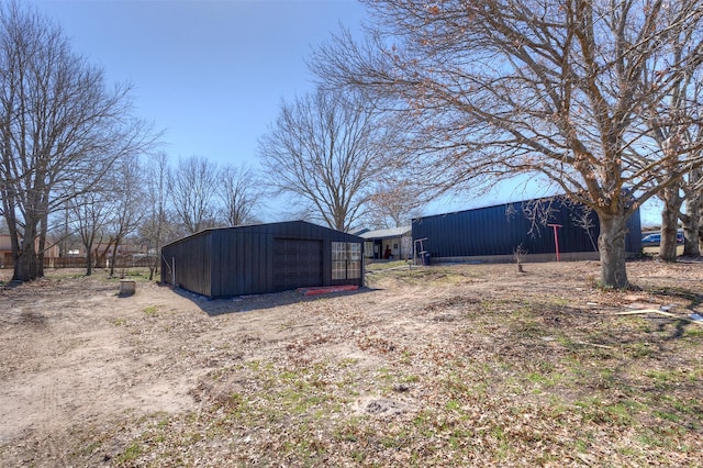 view of yard featuring an outbuilding, a garage, driveway, and an outdoor structure