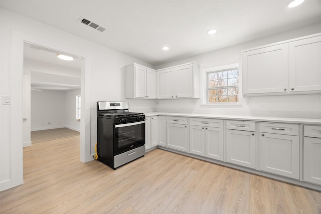 kitchen featuring visible vents, stainless steel range with gas cooktop, light countertops, and light wood finished floors