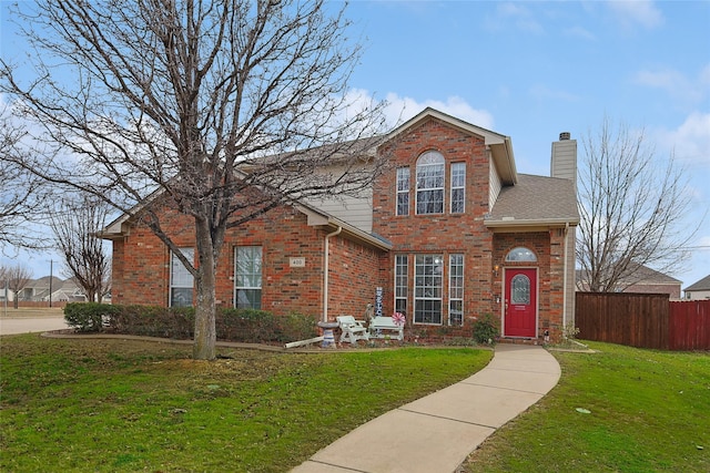 traditional-style home with fence, roof with shingles, a chimney, a front lawn, and brick siding