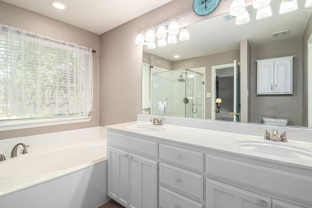 bathroom featuring toilet, visible vents, a stall shower, and a sink