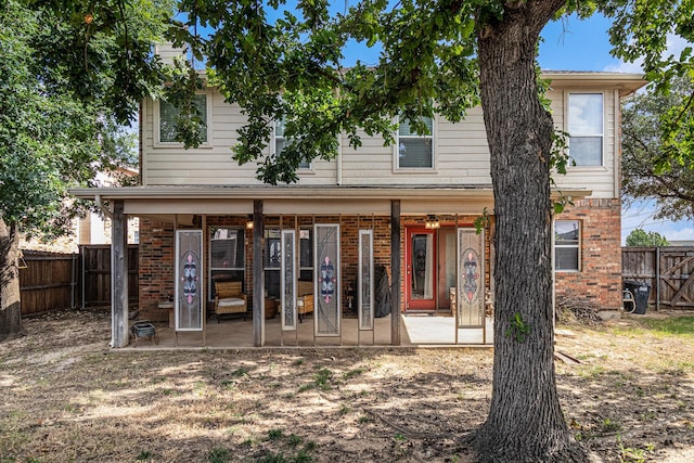 rear view of property featuring brick siding, a patio area, and a fenced backyard