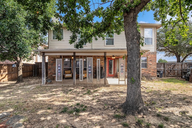 rear view of property with a patio, a fenced backyard, and brick siding