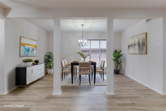 dining space featuring a chandelier, baseboards, light wood-style flooring, and ornate columns