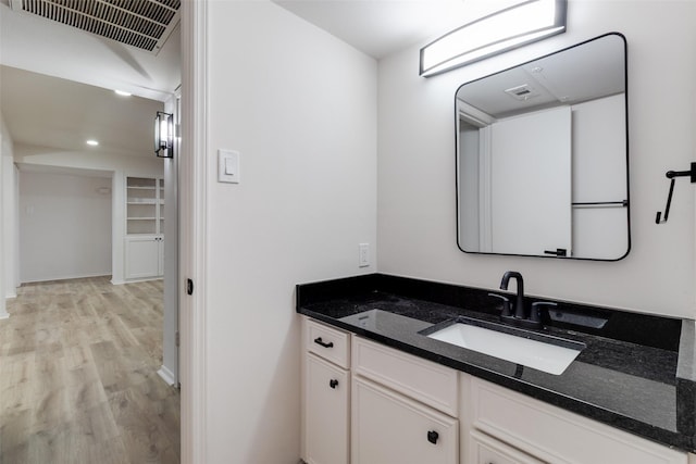 bathroom with recessed lighting, visible vents, wood finished floors, and vanity