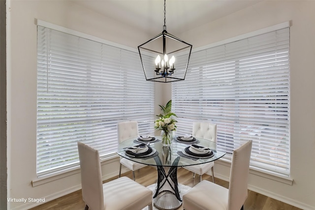 dining area featuring a notable chandelier, baseboards, and wood finished floors