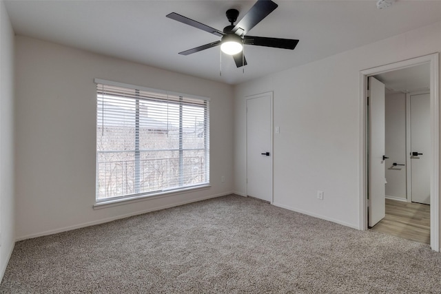 spare room featuring light carpet and a ceiling fan