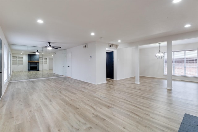 unfurnished living room featuring light wood finished floors, visible vents, recessed lighting, a fireplace, and ceiling fan with notable chandelier