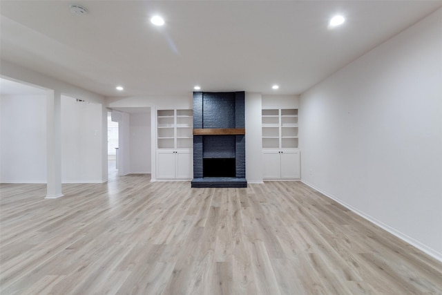 unfurnished living room with recessed lighting, a brick fireplace, baseboards, and light wood-style floors