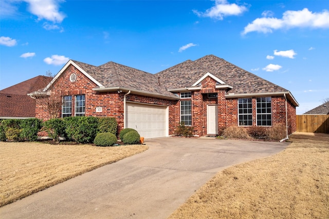 ranch-style house featuring a garage, brick siding, driveway, and fence