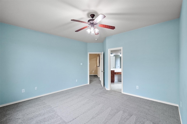 unfurnished bedroom with ceiling fan, baseboards, carpet floors, and connected bathroom