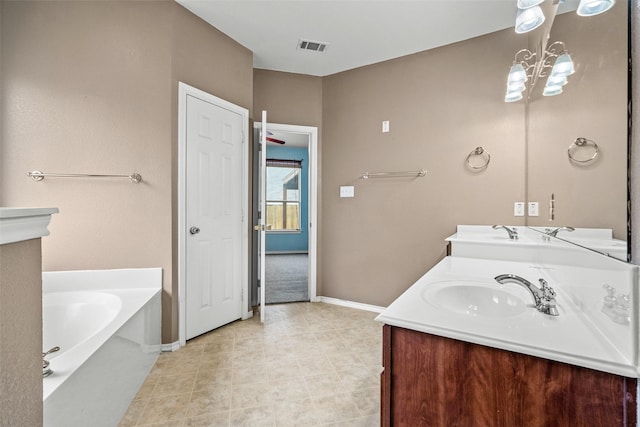 bathroom with a garden tub, double vanity, visible vents, and a sink