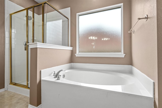 full bathroom with tile patterned floors, a bath, and a stall shower