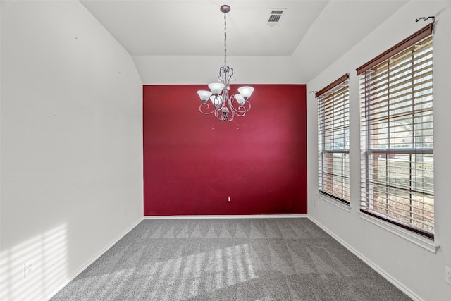 carpeted empty room with visible vents, baseboards, and an inviting chandelier