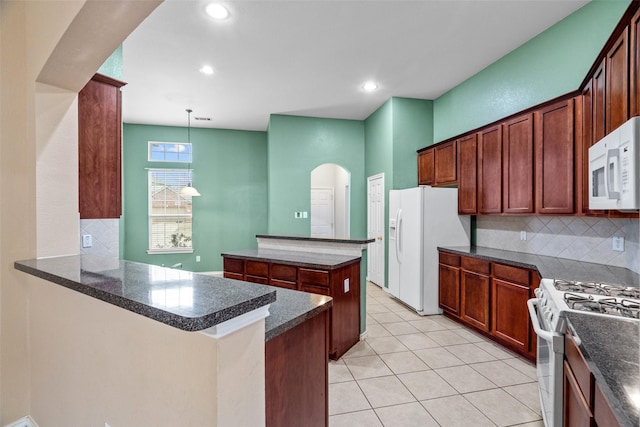 kitchen featuring tasteful backsplash, a center island, light tile patterned floors, arched walkways, and white appliances