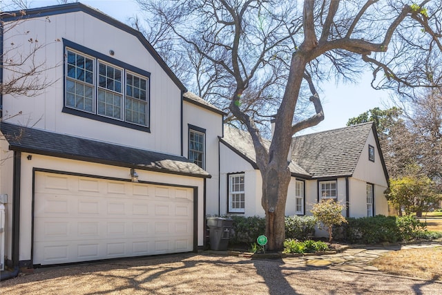 view of front facade featuring a garage, driveway, and a shingled roof