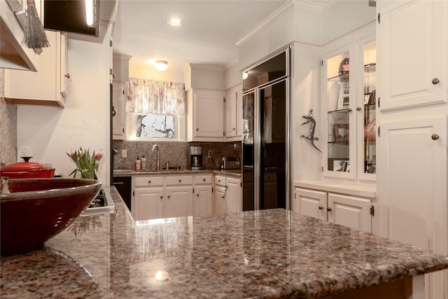 kitchen with white cabinetry, decorative backsplash, glass insert cabinets, and crown molding