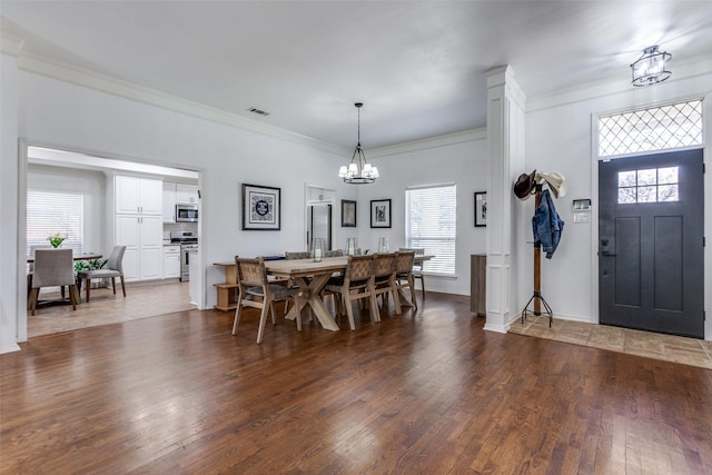 dining space featuring plenty of natural light, an inviting chandelier, and wood finished floors