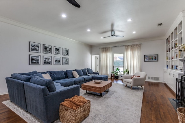 living area with ornamental molding, visible vents, and ceiling fan