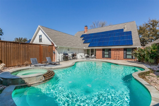 view of pool with a patio, outdoor dining area, fence, and a pool with connected hot tub