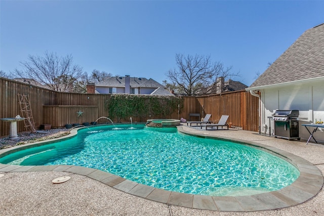 view of pool featuring a patio, a fenced backyard, a pool with connected hot tub, and a grill