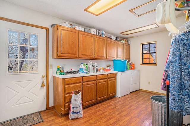 laundry room featuring light wood-style flooring, plenty of natural light, cabinet space, and independent washer and dryer