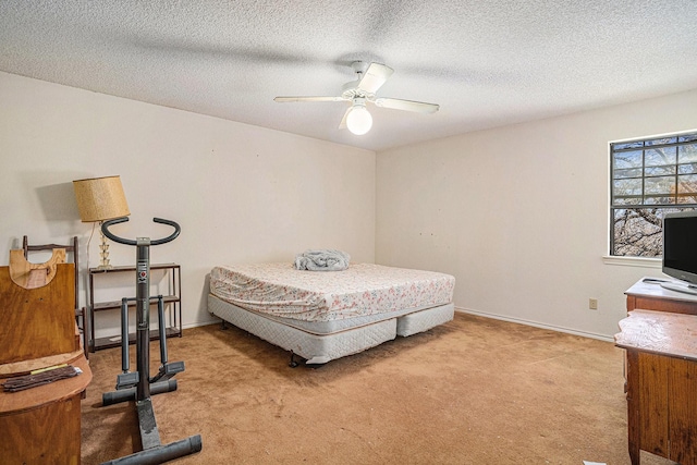 bedroom featuring light colored carpet, a textured ceiling, baseboards, and ceiling fan