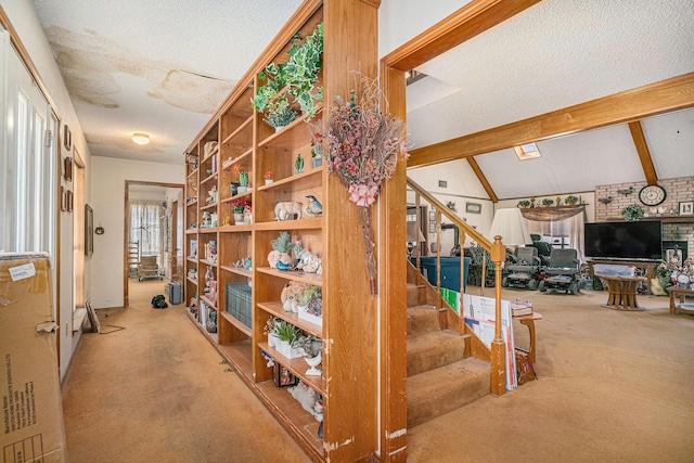 staircase with vaulted ceiling with beams, carpet floors, and a textured ceiling