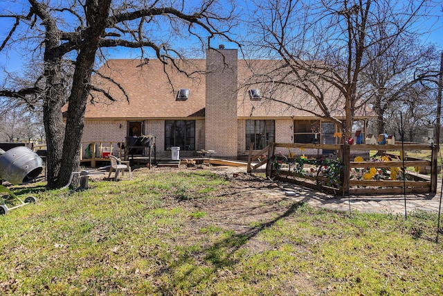 rear view of house featuring a shingled roof, fence, brick siding, and a chimney