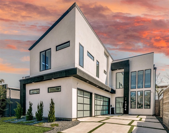 exterior space featuring concrete driveway, a garage, and stucco siding