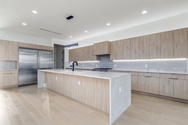 kitchen with light brown cabinetry, modern cabinets, and built in fridge