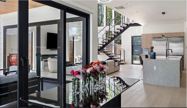 interior space with stairs, visible vents, light wood-style flooring, and floor to ceiling windows