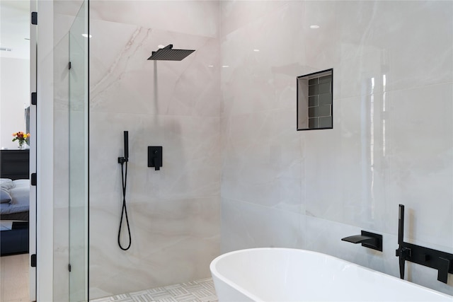 ensuite bathroom featuring a tile shower, a freestanding bath, and ensuite bathroom