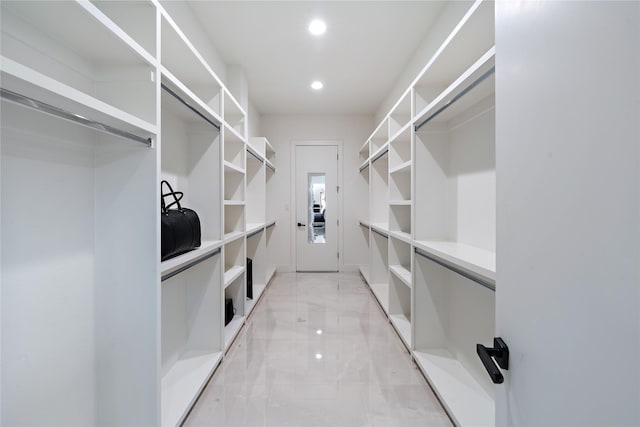 walk in closet featuring marble finish floor