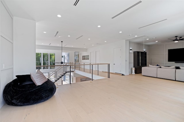 living area featuring light wood-type flooring, an upstairs landing, visible vents, recessed lighting, and attic access