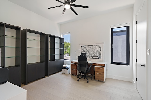 office featuring light wood-type flooring, baseboards, and a ceiling fan