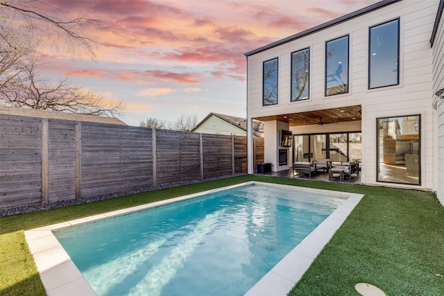 view of pool featuring an outdoor living space, a fenced in pool, a yard, a fenced backyard, and a patio