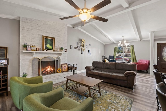 living area featuring baseboards, lofted ceiling with beams, ceiling fan with notable chandelier, a fireplace, and wood finished floors