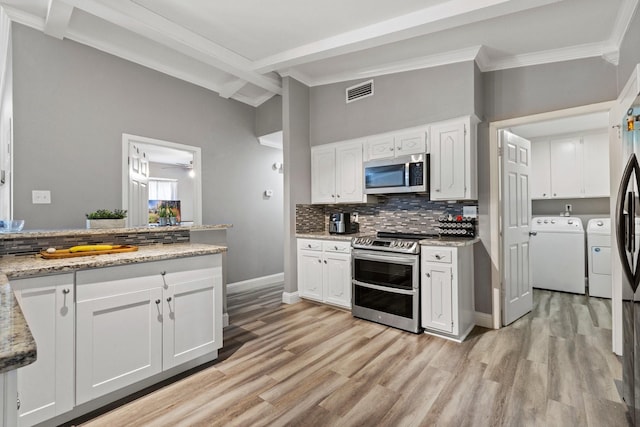 kitchen with tasteful backsplash, visible vents, lofted ceiling with beams, washer and dryer, and stainless steel appliances