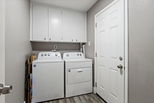 laundry room with cabinet space, wood finished floors, and washer and clothes dryer