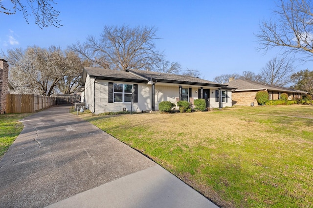 view of front facade featuring central AC, a front lawn, and fence