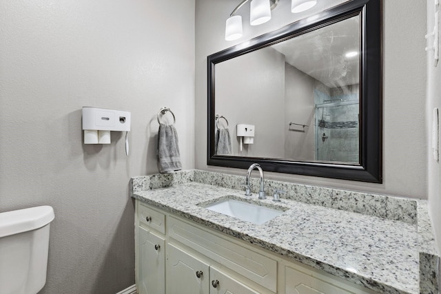 full bath featuring toilet, a stall shower, and vanity